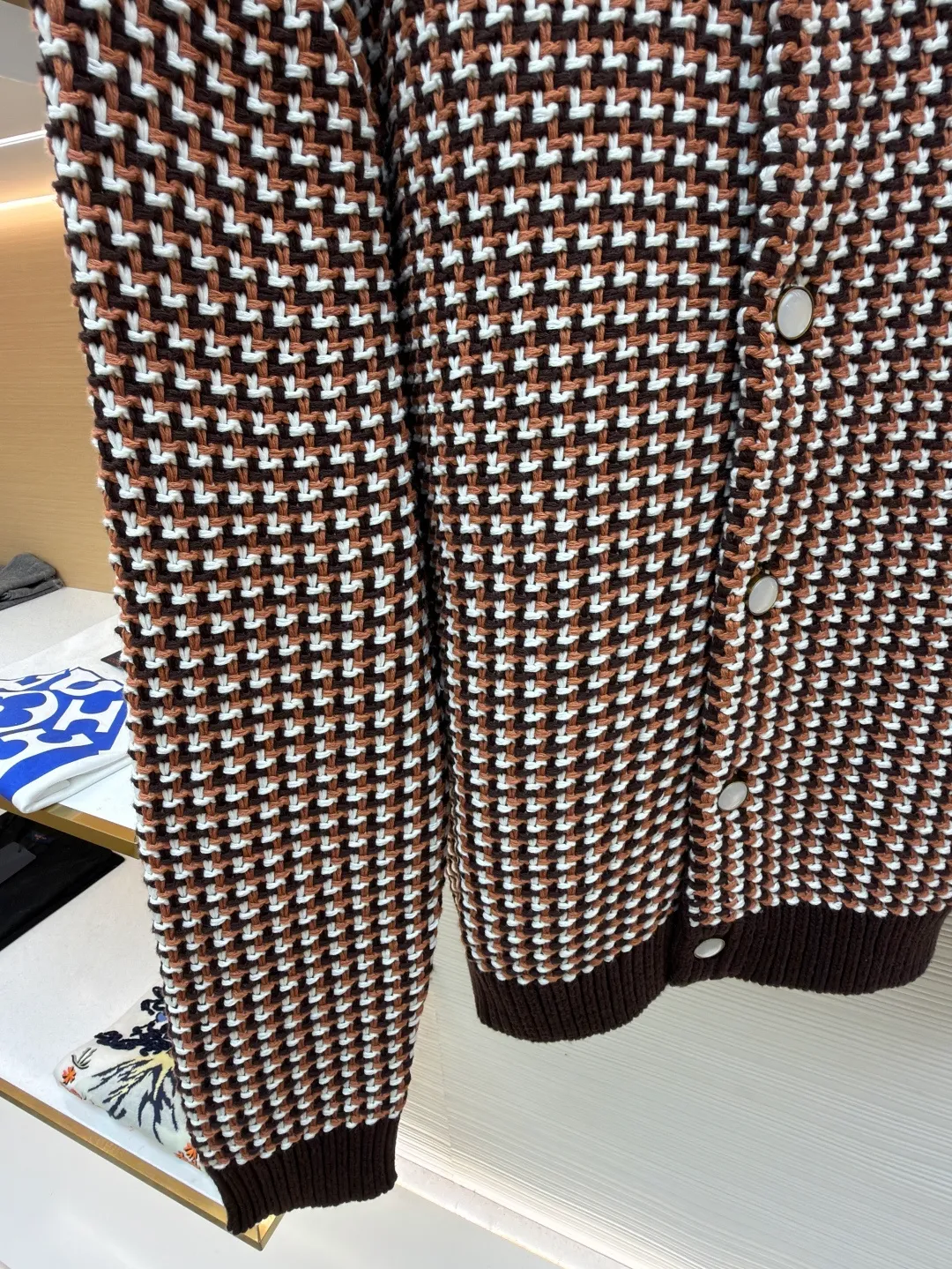 LOUIS VUITTON Thick needle houndstooth color block jacquard pearl button knitted cardigan ●Item number: 1682237-B95 ●Material: wool blended fabric ●Technology: knitted jacquard production ●Color: pattern ●Version: fitted version ●Weight: about 1220 grams ●Size: S-M-L-XL ●Description: This houndstooth knitted cardigan is woven with worsted wool blended yarn. It uses double-ply threading technology to make the yarn tighter. It uses yarn-dyed jacquard technology to create a classic houndstooth pattern. The pattern is clear and symmetrical, with natural color transitions and is not easy to fade. The body of the garment uses a four-knit knitting process. The fabric has high density, good elasticity, and good warmth retention and anti-pilling properties. The neckline, cuffs and hem are designed with ribbed edges and are made of high-elastic spandex blended ribs, which will not easily loosen and deform after long-term wear. The placket is equipped with matte mother-of-pearl buttons, which are hand-polished and polished for a warm texture. The overall design adopts three-dimensional tailoring, and the stitching between the shoulders and body uses embedded clip technology. The stitching is smooth and has no bulges. The spacing of each stitch is precisely controlled, and the exquisite knitting craftsmanship and ingenuity are displayed in every detail. The overall wiring is straight and delicate, the fabric is comfortable and soft, and the color is consistent without color difference. It can be matched with the same style to create a fashionable look and control various occasions. Customized accessories, complete with three standards, same style for men and women!